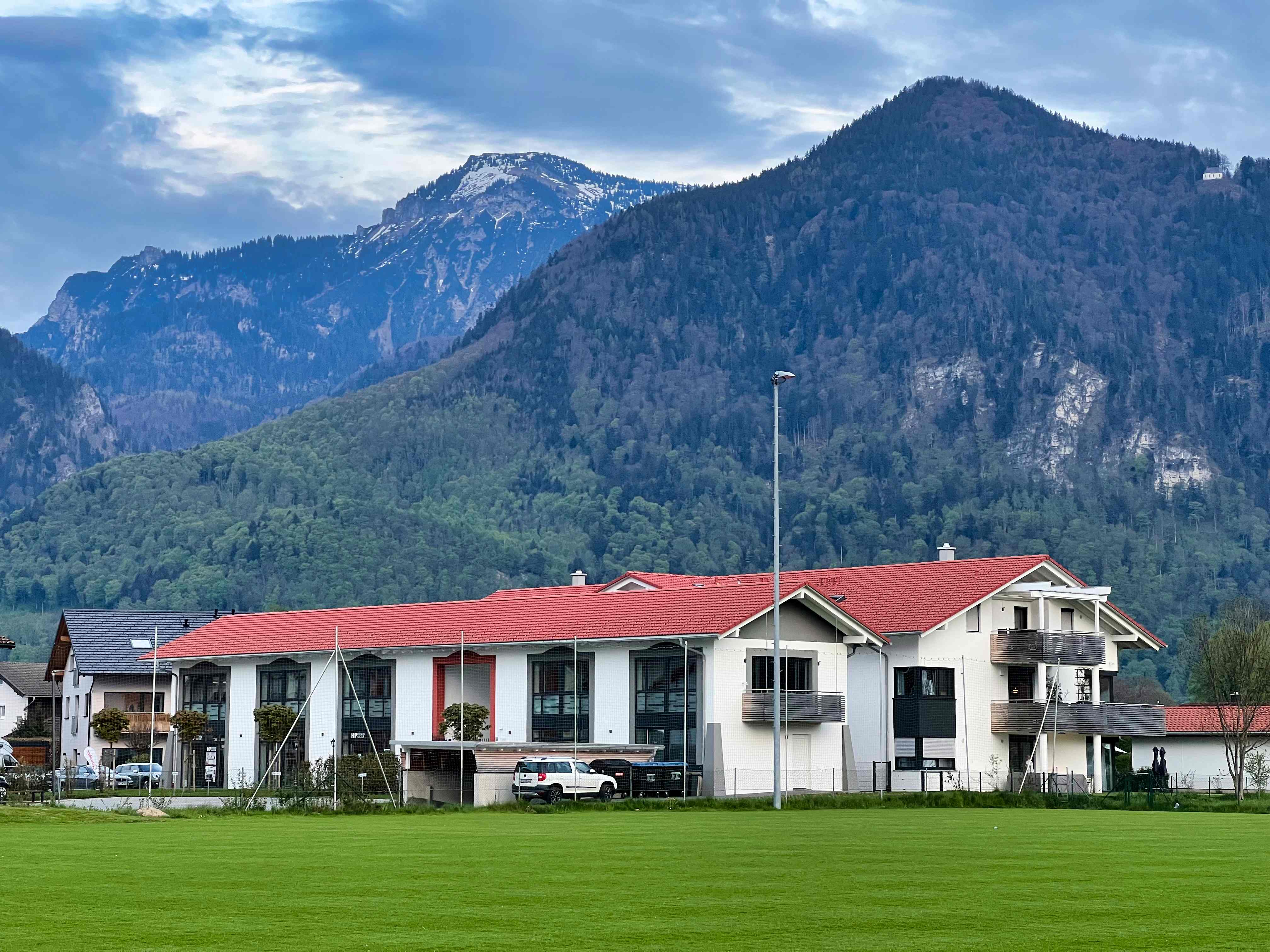 Moderner Wohnbau mit Bergpanorama im Frühling